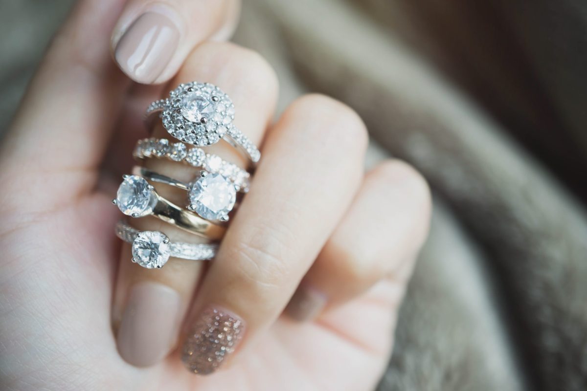Close up of an elegant diamond ring on woman finger with white f Natural vs. lab grown diamonds