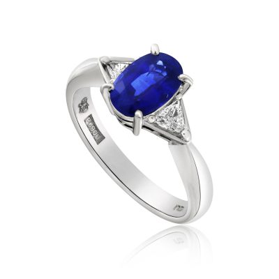 A three stone trilogy blue sapphire and diamond engagement ring in platinum