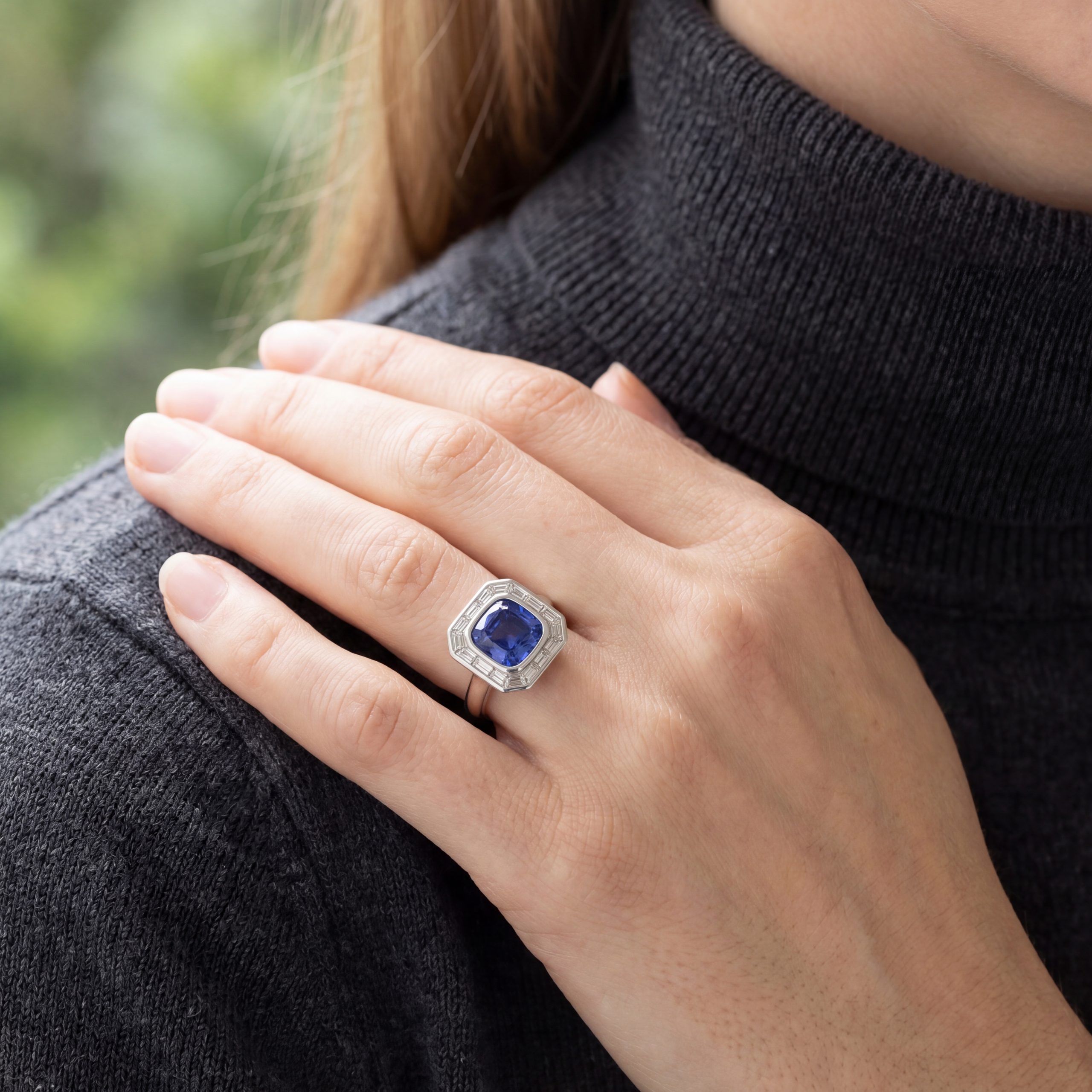 model wearing sapphire and diamond cushion cluster ring
