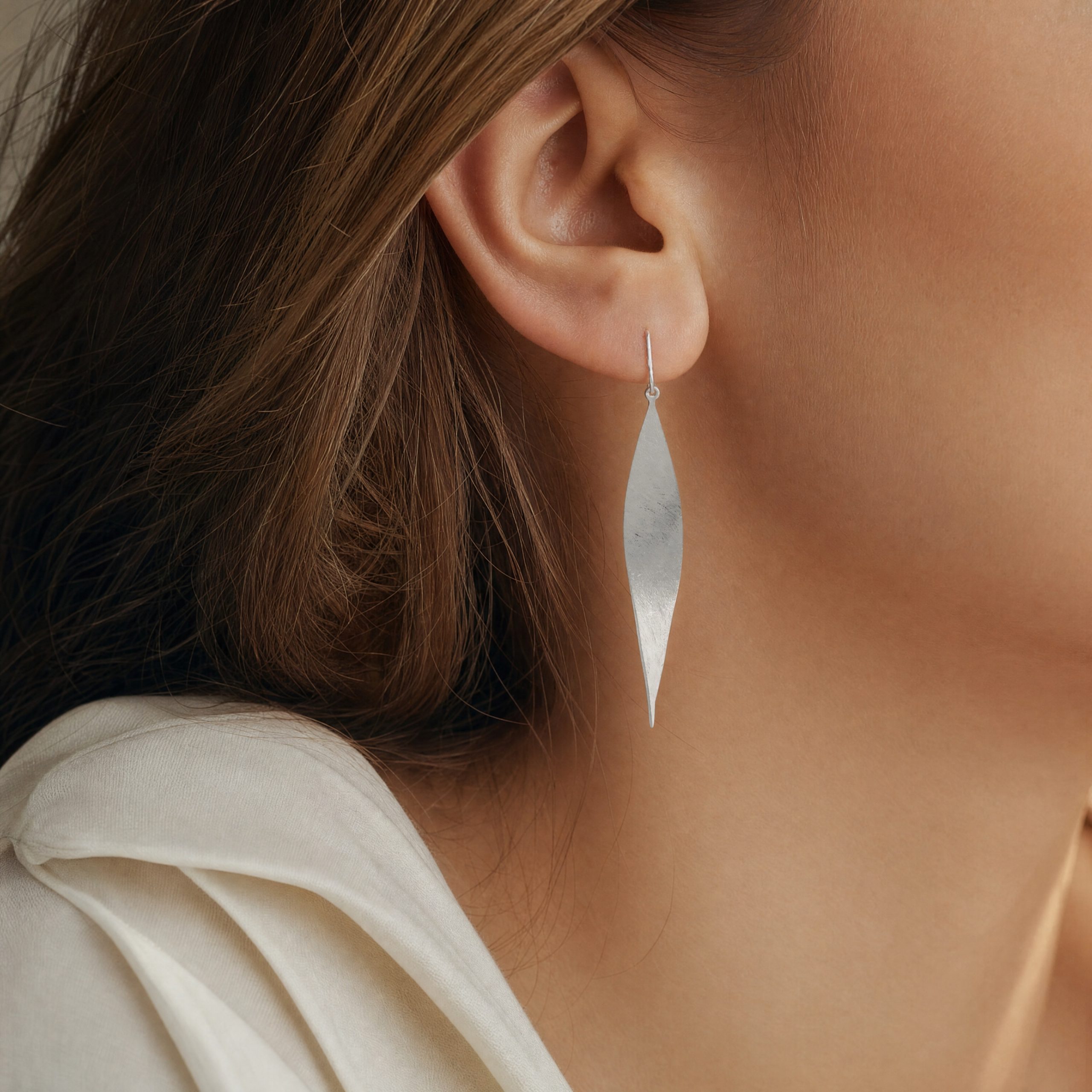25282 Model wearing silver leaf twist earrings